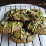 Close-up of six vegan matcha green tea cookies with white chocolate chunks, arranged on a wire rack.
