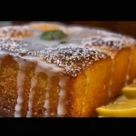 Close-up of a lemon poppy seed loaf cake with a white glaze.