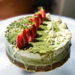 Delicious matcha and strawberry cake, decorated with fresh strawberries and matcha drizzle.