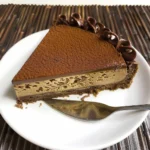 Delicious no-bake Nutella cheesecake, dusted with cocoa powder, a slice removed.