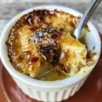 Close-up of a spoonful of crème brûlée with a crisp caramelized sugar topping.