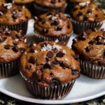 Close-up overhead shot of six delicious chocolate chip muffins in muffin liners.