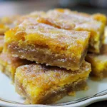 A close-up of a stack of Palha Italiana de Maracujá, a Brazilian dessert, dusted with powdered sugar.
