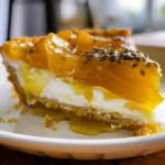 A slice of creamy passion fruit meringue pie on a white plate.